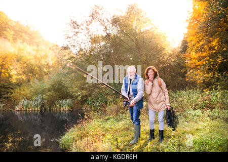 Coppia senior Pesca al lago in autunno. Foto Stock