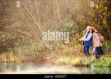 Coppia senior Pesca al lago in autunno. Foto Stock