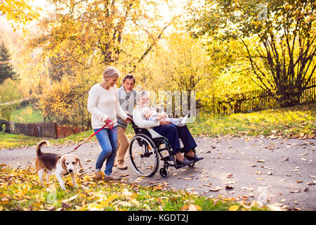 Famiglia estesa con il cane in una passeggiata nella natura d'autunno. Foto Stock