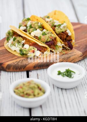 Le carni bovine macinate tacos su legno su sfondo grigio Foto Stock