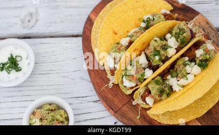 Le carni bovine macinate tacos su legno su sfondo grigio Foto Stock