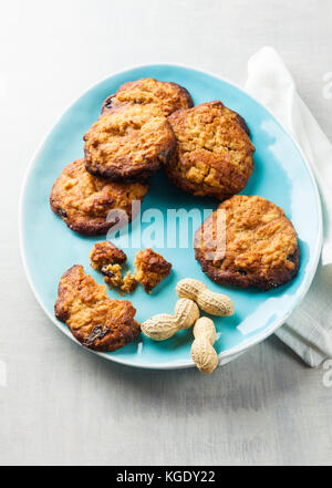 Biscotti al burro di arachidi e marmellata su una piastra blu su bianco sullo sfondo di pietra Foto Stock