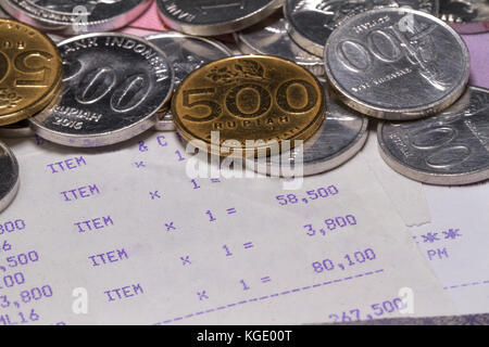 Spese di denaro e pagamenti illustrati da vicino con monete, banconote e ricevute Foto Stock