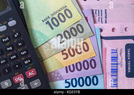 Vista dall'alto / calcolo del calcolo del calcolo del costo e dei pagamenti con ricevuta, banconote e calcolatrice Foto Stock