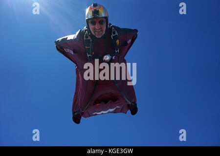 Wingsuit pilota è volare alto nel cielo sopra le Alpi. In tal modo il ponticello è volare gratis per un lungo periodo di tempo e con un grande sorriso sul suo volto. Foto Stock