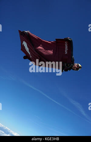 Wingsuit pilota è volare alto nel cielo sopra le Alpi. In tal modo il ponticello è volare gratis per un lungo periodo di tempo e con un grande sorriso sul suo volto. Foto Stock