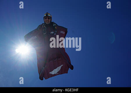 Wingsuit pilota è volare alto nel cielo sopra le Alpi. In tal modo il ponticello è volare gratis per un lungo periodo di tempo e con un grande sorriso sul suo volto. Foto Stock