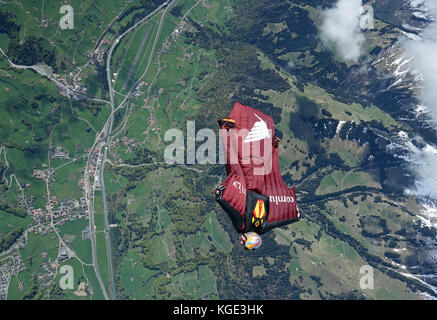 Wingsuit pilota è volare alto nel cielo sopra le Alpi. In tal modo il ponticello è volare gratis per un lungo periodo di tempo e con un grande sorriso sul suo volto. Foto Stock