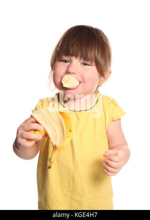 2 anno di età bambino mangiare una banana in un studio Foto Stock