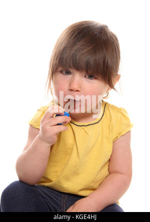 Due anno vecchia ragazza mangiare il cioccolato in studio Foto Stock