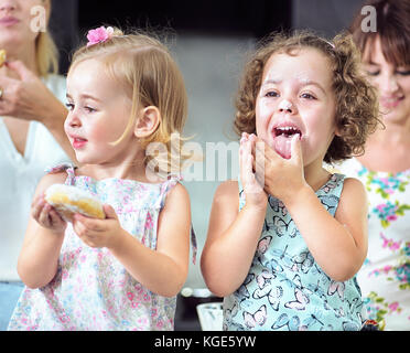 Due cute ragazze mangiare dolci gustosi bomboloni Foto Stock