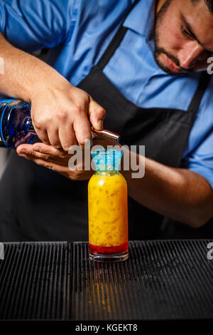 Il barista è rendere fantasiosi cocktail multicolore Foto Stock