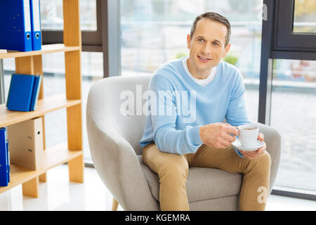 Bel lieto uomo avente il tè Foto Stock