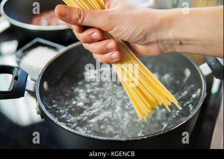 Cucinare gli spaghetti in una pentola con acqua bollente Foto Stock