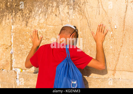 Israele la Terra Santa Gerusalemme Città Vecchia religiosa Ebreo Ebreo uomo kippur bianco cranio cappuccio che prega appoggiandosi entrambe le mani dal Western Wailing Wall Kotel Foto Stock