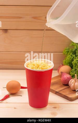 Mangiare tagliatelle istante con una bacchetta di legno. Foto Stock