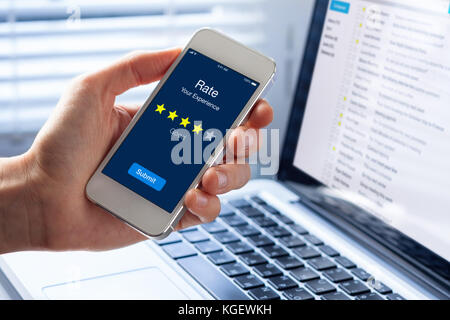 Rating persona la sua esperienza con 4 stelle sullo smartphone app schermo, concetto online circa la soddisfazione del cliente il feedback e la valutazione della qualità del serv Foto Stock