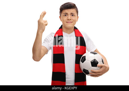 Teenage tifoso di calcio con una sciarpa e un calcio tiene le dita incrociate per fortuna isolati su sfondo bianco Foto Stock