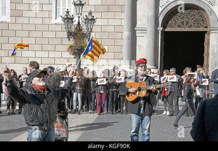 Un uomo non identificato sventola bandiere catalane, a sinistra, come secondo uomo non identificato suona una chitarra con le parole 'libertà per Catalunya' scritte su di essa, a destra, sulla strada di fronte al Palau de la Generalitat de Catalunya come sostengono per l'indipendenza catalana dalla Spagna il martedì 7 novembre, 2017. L'edificio è un palazzo storico di Barcellona, in Catalogna, che ospita gli uffici della Presidenza della Generalitat de Catalunya Barcellona. Credito: Ron Sachs/CNP /MediaPunch Foto Stock