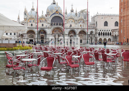 Venezia, Veneto, Italia. 7 Nov, 2017. Acqua Alta alta marea di 115cm dalla laguna provocando allagamenti temporanei in Piazza San Marco. Passarelle, o passerelle elevate, sono installati per il traffico pedonale. Il ristorante vuoto sedie in piedi nell'acqua. Credito: Maria Clarke/Alamy Live News Foto Stock