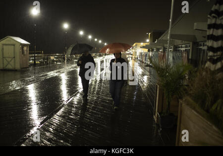 Asbury Park, New Jersey, Stati Uniti. 7 novembre 2017. Due donne camminano lungo il lungomare vicino all'Asbury Park Convention Center di Asbury Park, New Jersey. Il centro congressi è il sito del quartier generale notturno del New Jersey Democratic Return per il candidato governatore Phil Murphy. Murphy dovrebbe vincere l'ufficio. Credito: Brian Branch Price/ZUMA Wire/Alamy Live News Foto Stock