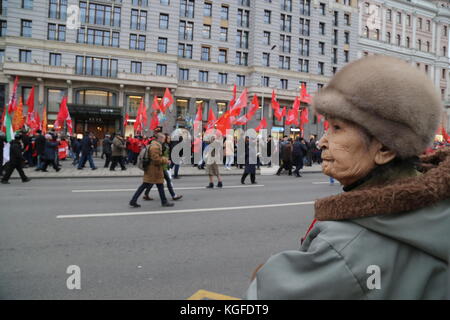 Mosca, Mosca, Russia. 7 novembre 2017. Una donna in piedi sul marciapiede e osserva la marcia. Migliaia di persone marciarono verso Piazza della Rivoluzione nel centro di Mosca per commemorare il 100° anniversario della Rivoluzione russa. Molti portavano ritratti di Lenin, Stalin e bandiere con l'emblema dell'Unione Sovietica. La marcia includeva anche persone provenienti da diversi paesi tra cui Cina, Italia, Venezuela, Brasile e Cuba. Crediti: Nicholas Muller/SOPA/ZUMA Wire/Alamy Live News Foto Stock