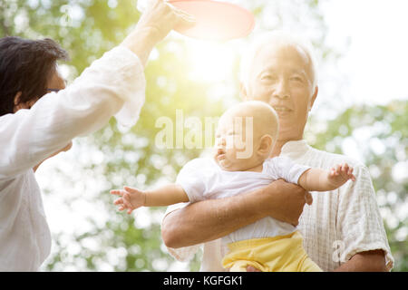 Nonni avendo cura di baby nipote nel parco all'aperto. famiglia asiatica, assicurazione vita concetto. Foto Stock