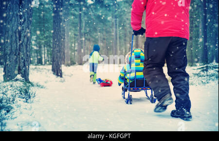 Padre con figli a piedi la nevicata Foto Stock