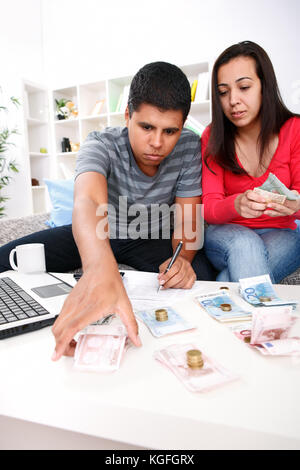 Felice coppia giovane di smistamento di casa loro finanze. Foto Stock