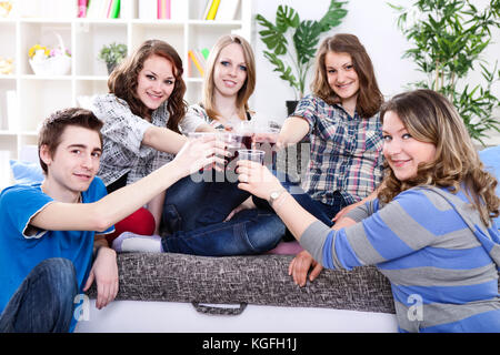 Gruppo di adolescenti in feste private con occhiali sollevata dopo un toast Foto Stock