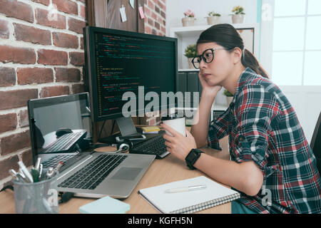 Piuttosto la bellezza lady computer lavoratore guardando i dati di codice sensazione preoccupato quando ella lo sviluppo on-line il nuovo sistema di sicurezza avente il problema. Foto Stock