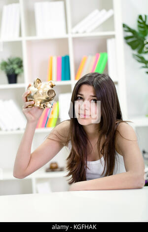 Giovane adolescente infelice ragazza con vuoto piggybank Foto Stock