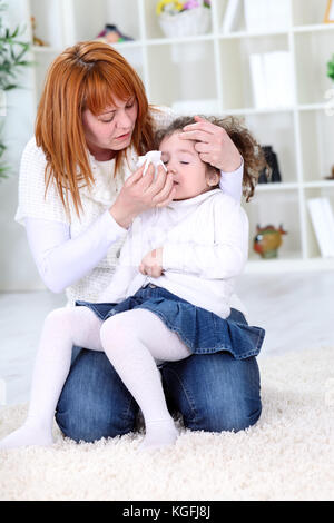 Madre tergi malati figlia del naso con il tessuto Foto Stock