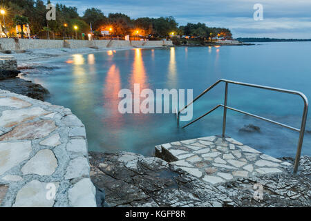 Sumer mediterranea resort con mare adriatico spiaggia rocciosa a sera. Istria, Croazia Foto Stock