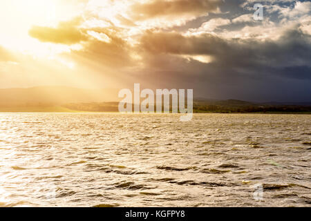 Acqua sotto la luce del sole e la tempesta scuro. Foto Stock
