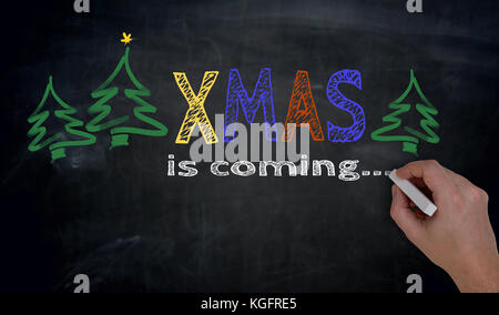 Xmas è scritta a mano sulla lavagna. Foto Stock