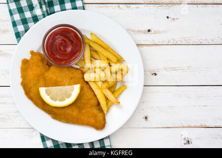 La Wiener Schnitzel con patate fritte in bianco sullo sfondo di legno Foto Stock