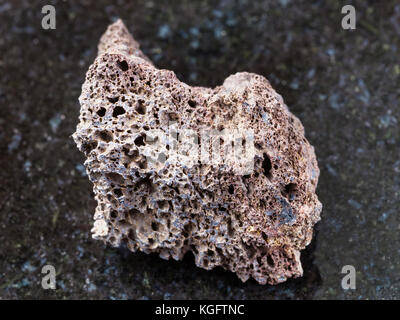 Le riprese in modalità macro di minerale naturale campione di roccia - pomice ruvida di composizione di base sulla pietra di granito scuro dello sfondo Foto Stock