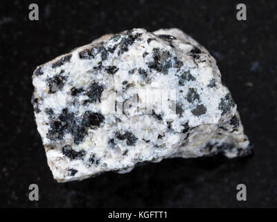 Le riprese in modalità macro di minerale naturale campione di roccia - ruvido granito bianco sulla pietra di granito scuro dello sfondo Foto Stock