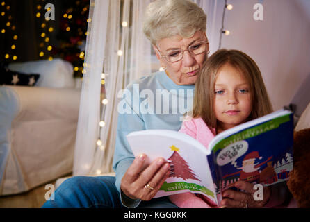 Nonna e nipote lettura storybook nel letto Foto Stock