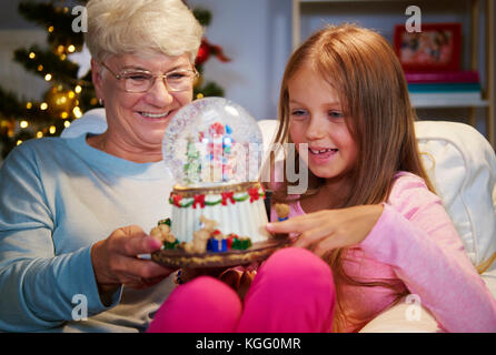 Senior donna con la nipote tenendo una decorazione natalizia Foto Stock