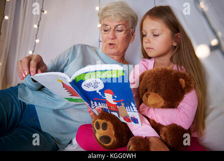 Nonna libro lettura fuori di suo nipote Foto Stock