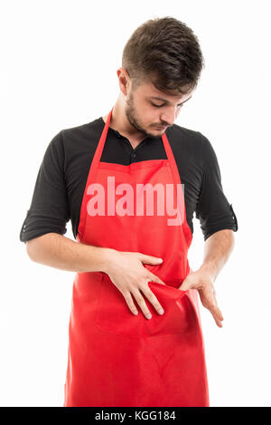 Supermercato maschio datore di lavoro cercando nel suo grembiule pocket isolato su sfondo bianco Foto Stock