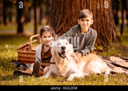 Bambini petting cane in posizione di parcheggio Foto Stock