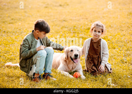 Bambini petting cane in posizione di parcheggio Foto Stock