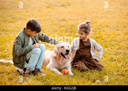 Bambini petting cane in posizione di parcheggio Foto Stock