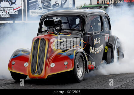 Alan O Connor burn out il suo Al's Gasser fuorilegge Anglia a Santa Pod Raceway Foto Stock