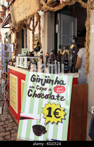 Segno pubblicità Ginjinha in un cioccolato fino al di fuori di un negozio nella città medievale di Óbidos, Portogallo, Ottobre 2017 Foto Stock