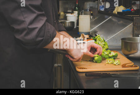 Lo chef prepara piatti nella cucina di un ristorante Foto Stock