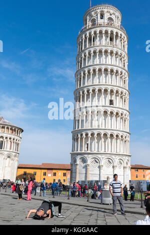 Pisa, Italia - ottobre 28th, 2017: giovani turisti fa una capriola nella parte anteriore della torre pendente di pisa mentre qualcuno scatta la sua immagine Foto Stock